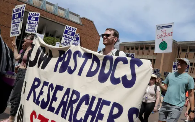 Protesting researchers with sign.