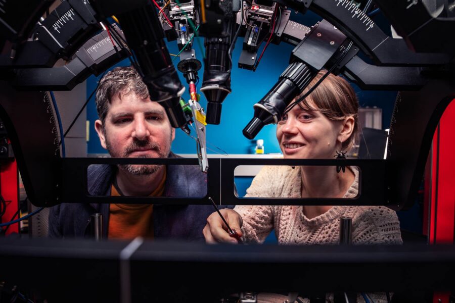 Josh Siegle and Anna Lakunina behind a microscope