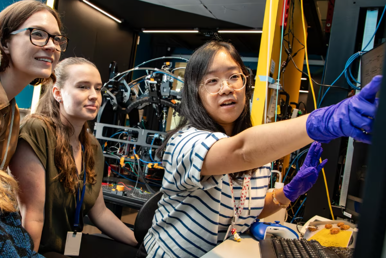 Sue Su (right), Allen Institute neural dynamics scientist,working with researchers Sam Tuggle (left) and Ella Hilton-VanOsdall(center) at the Allen Institute.
